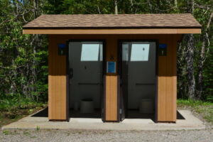 Dual pit toilet made of wood and concrete